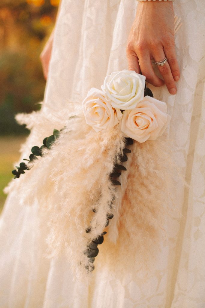 Woman holding white flower bouquet in white dress