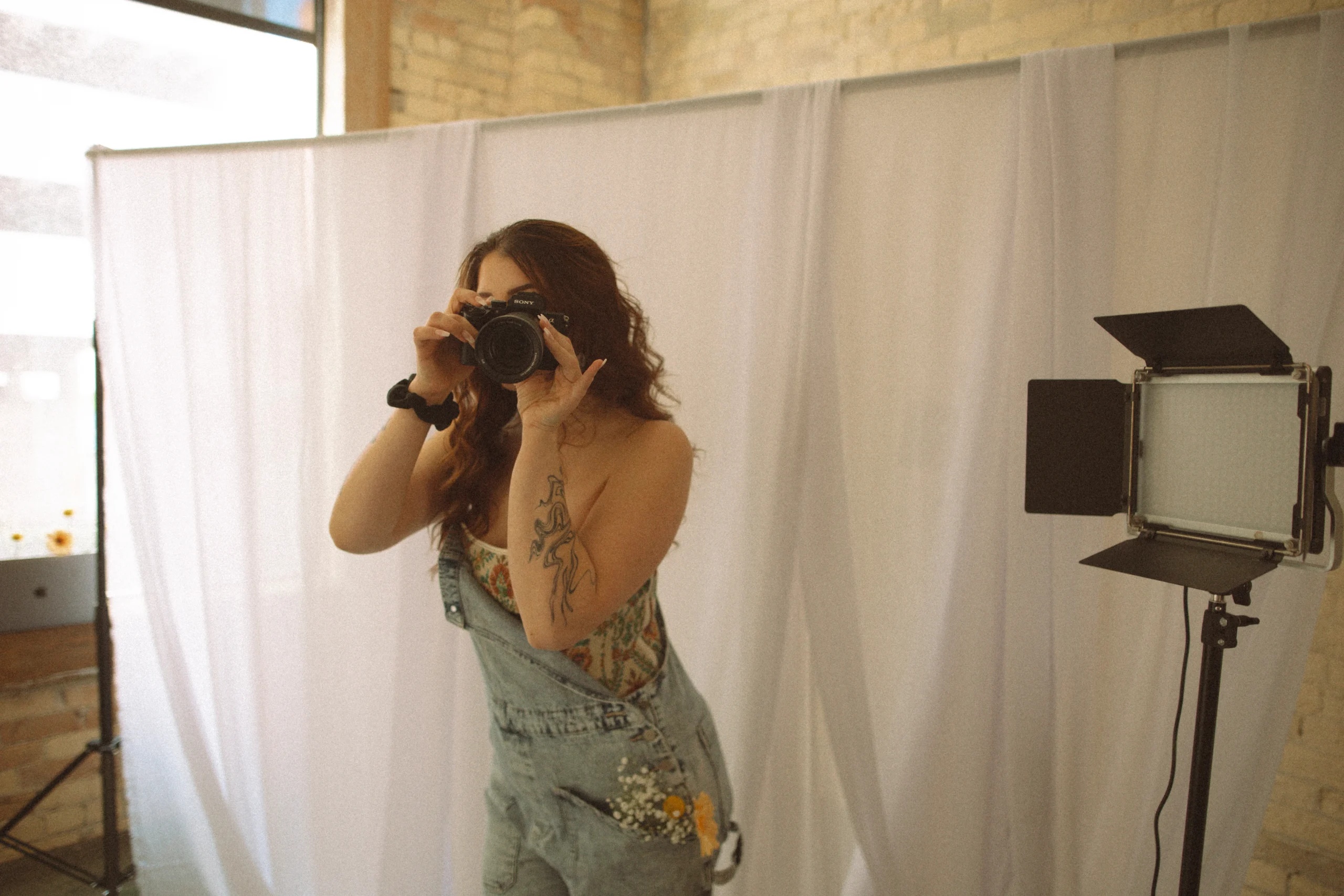 Mica taking a photo infront of white backdrop