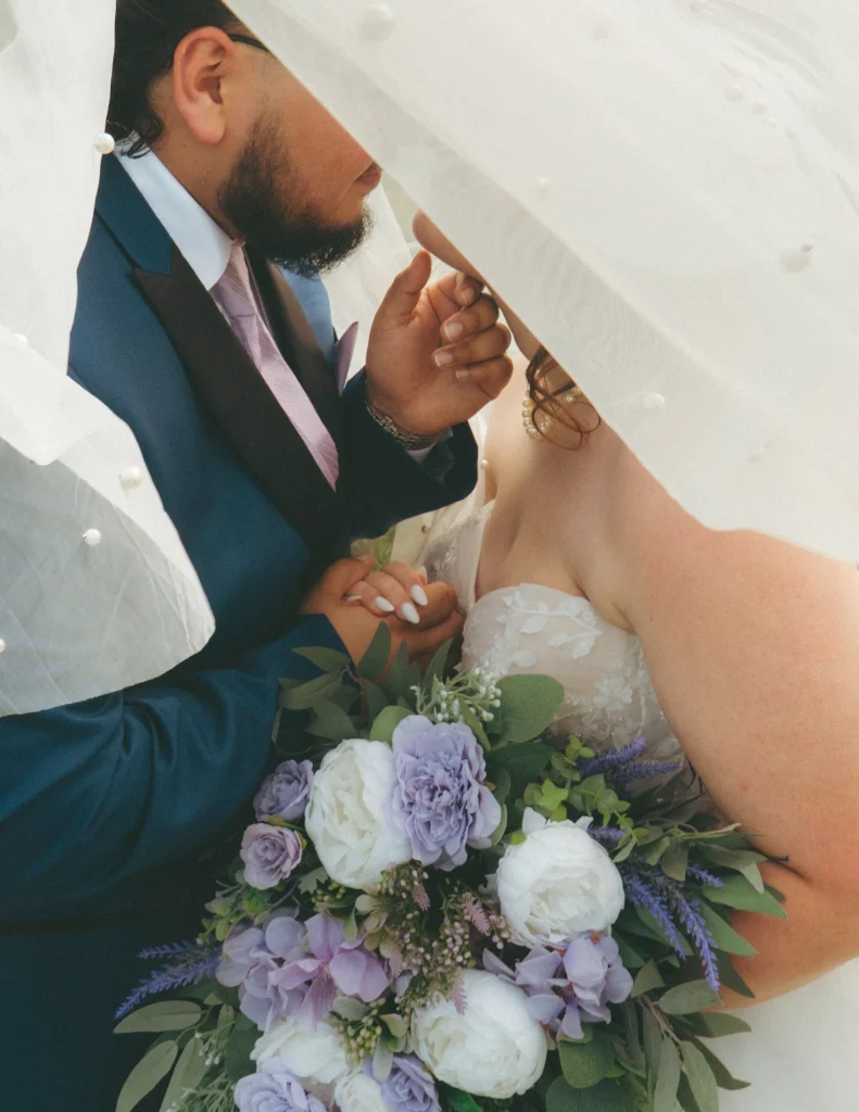 Bridesmaids in lavender dresses walking around bride as she smiles, creating motion blur.
