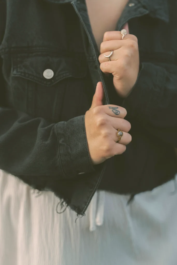 Black-and-white photo of a young man sitting shirtless on a wooden box, looking off to the side.