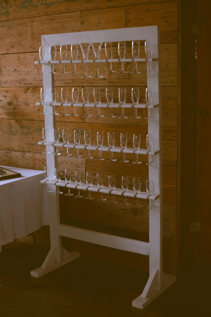 Display rack of empty champagne glasses arranged neatly against a rustic wooden wall.